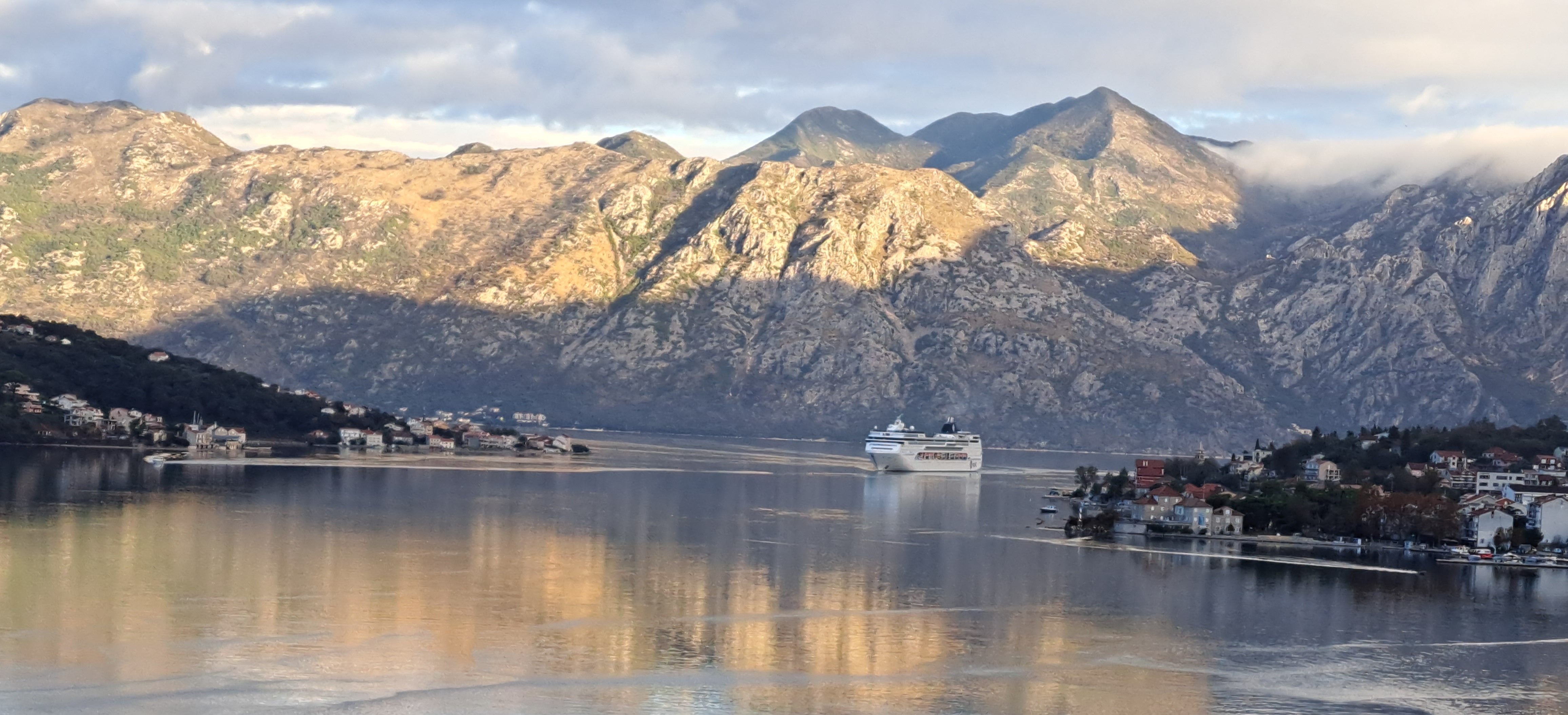picture of a bay surrounded by mountains and a cruise ship with text overlay describing the experiences and services offered by pgts.ca.